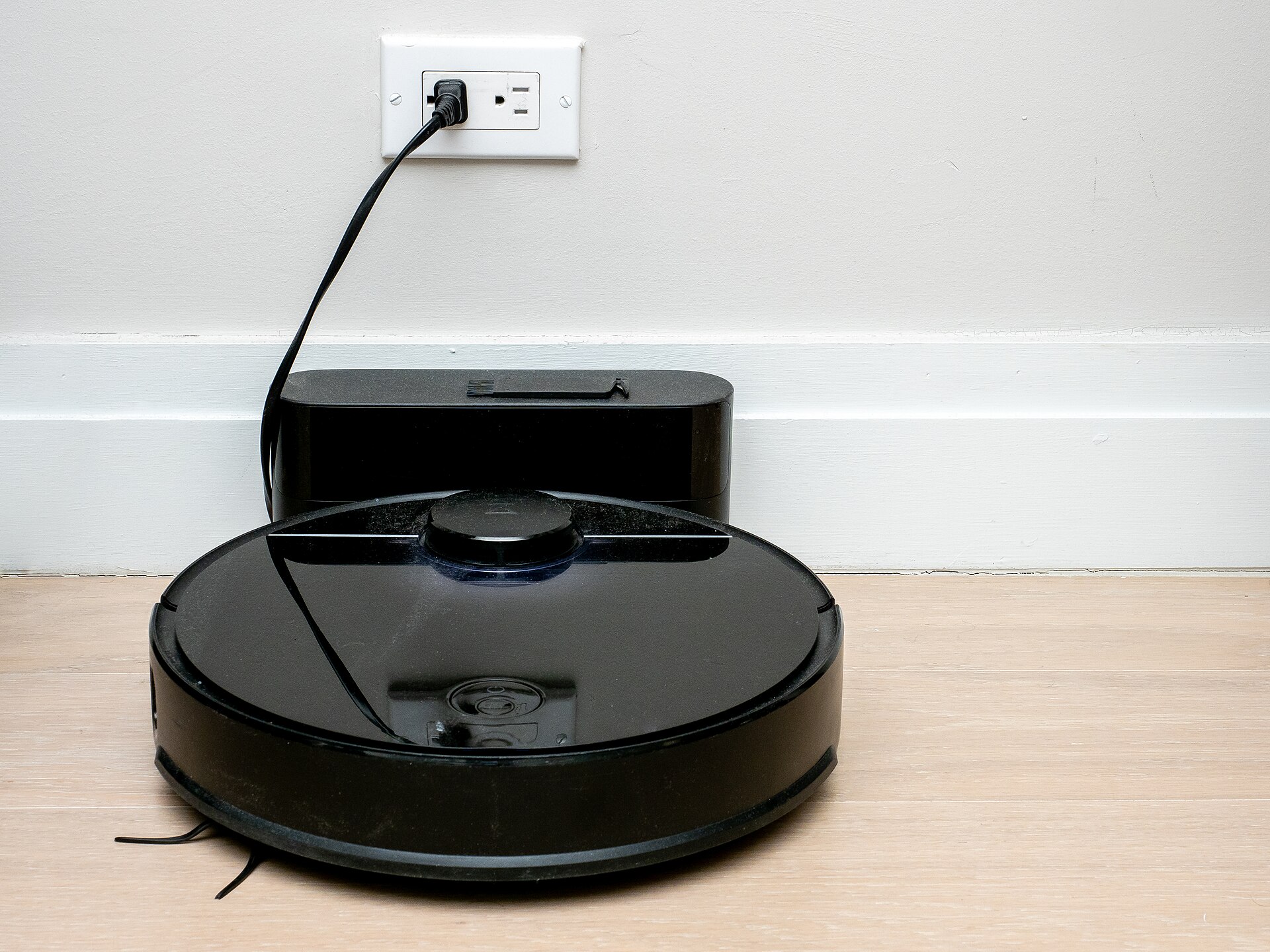 Aspirateur robot en train de se recharger sur sa base