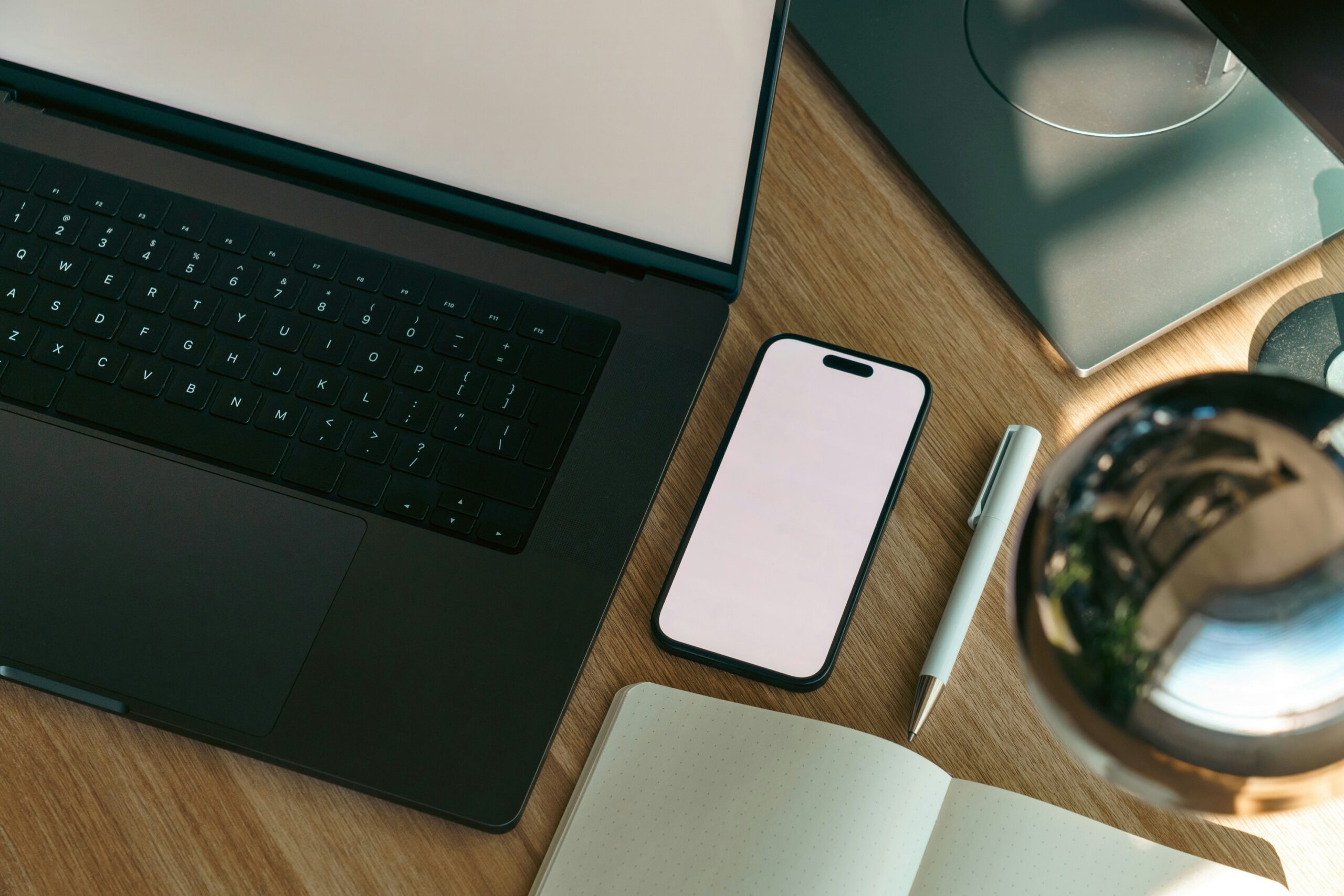 Téléphone, ordinateur et carnet sur un bureau, illustration des usages possibles de Muse.