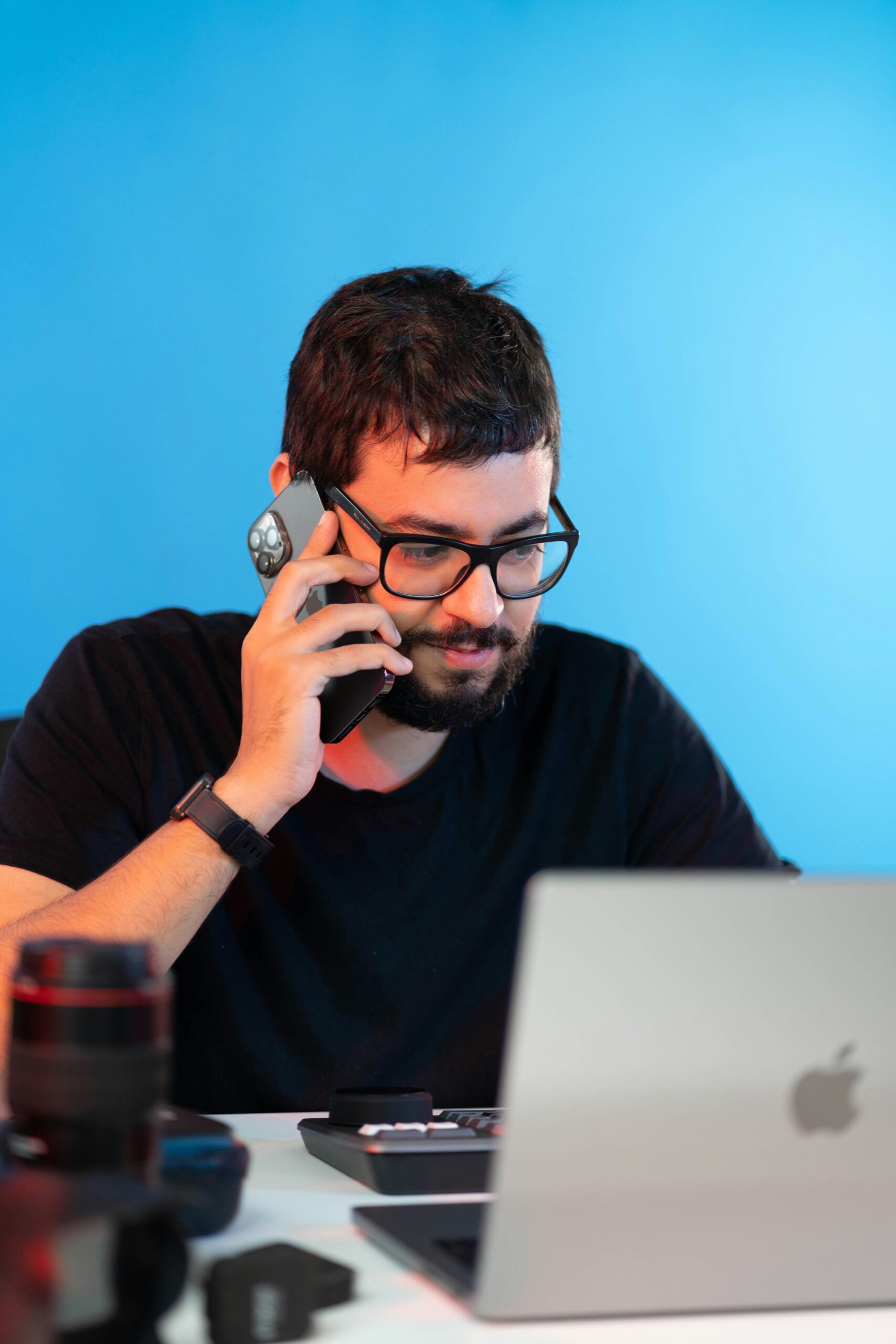 Personne au téléphone devant son ordinateur portable.